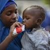 在世界粮食计划署在尼日利亚进行的饥荒评估活动中，一位流离失所的母亲在给孩子喂花生酱。