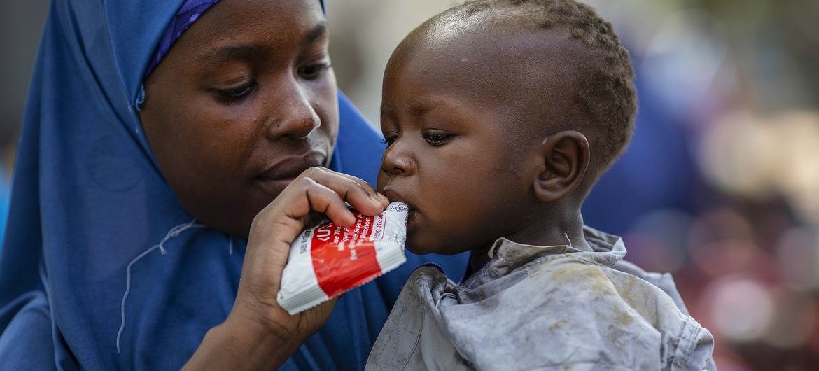 Une mère déplacée nourrit son bébé avec une pâte à base d'arachide lors d'un exercice d'évaluation de la famine mené par le PAM au Nigeria.