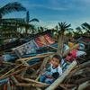 Un niño sentado en las runias de casas destruidas por el Tifón Ray u Odette, en Purok, Filipinas.