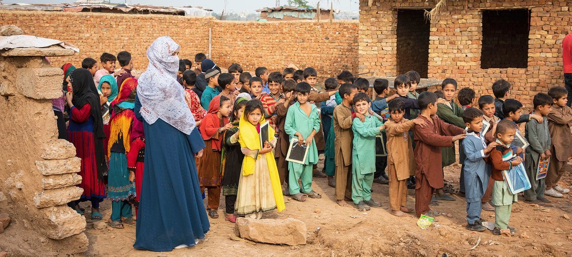 أطفال من اللاجئين الأفغان يقفون في طابور أمام مدرسة في إسلام أباد، باكستان.