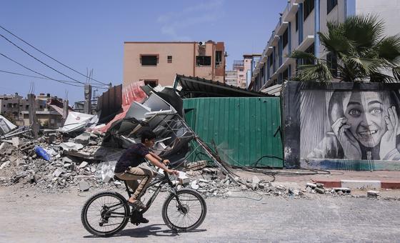 طفل يركب دراجته أمام مبانٍ دمرت خلال الهجوم على قطاع غزة.