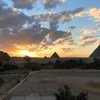मिस्र के गिज़ा में प्राचीन पिरामिड. दुनिया भर से पर्यटक, इन स्थलों को देखने के लिये आते हैं.