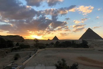 मिस्र के गिज़ा में प्राचीन पिरामिड. दुनिया भर से पर्यटक, इन स्थलों को देखने के लिये आते हैं.