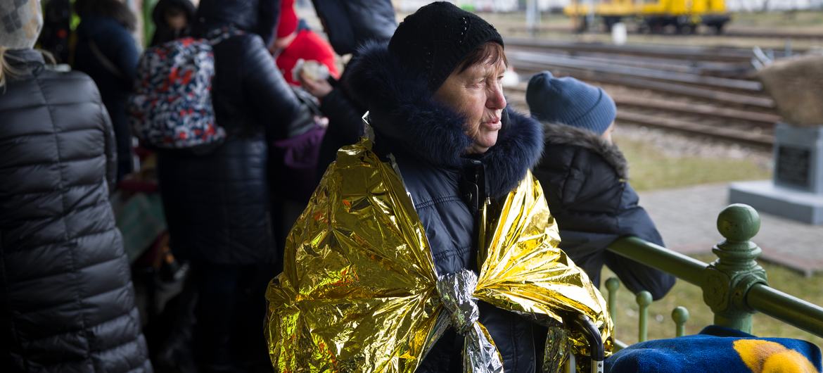 امرأة أوكرانية ترتدي بطانية الطوارئ عند وصولها إلى بولندا بعد فرارها من الصراع المتصاعد في أوكرانيا.