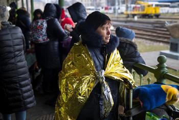 Une Ukrainienne porte une couverture d'urgence à son arrivée en Pologne après avoir fui l'escalade du conflit en Ukraine.