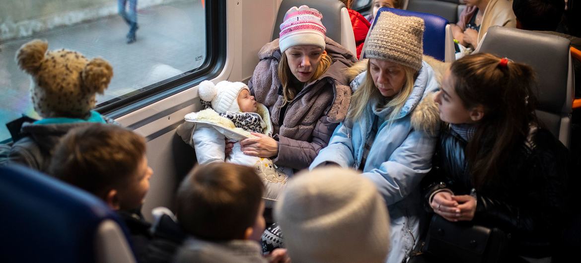 Famílias da Ucrânia em trem que segue para a Polônia 