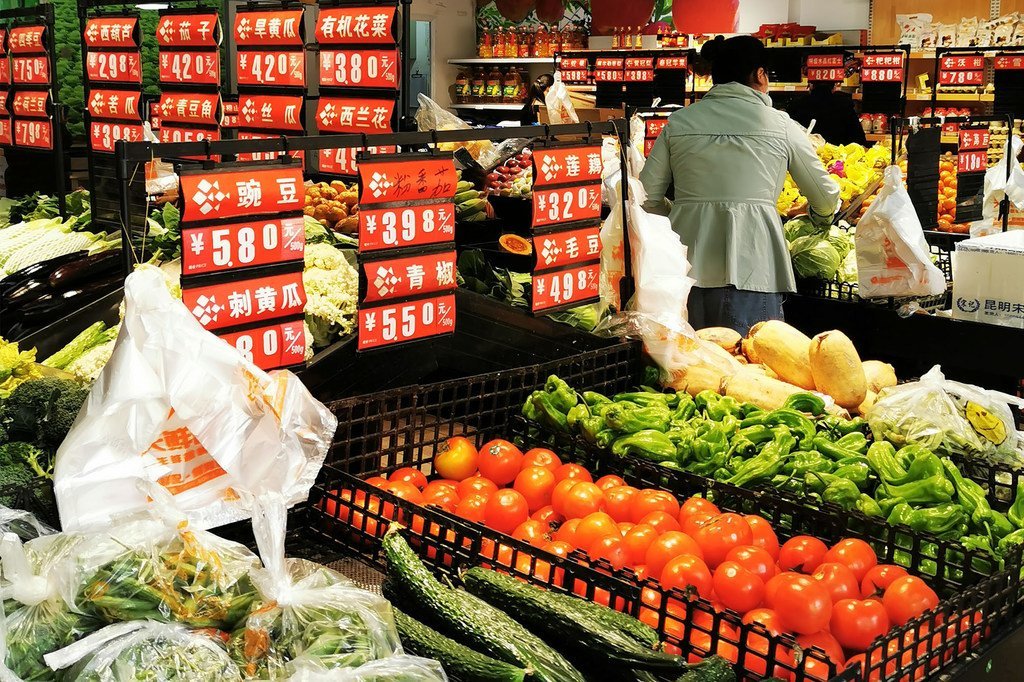 武汉一超市内，蔬菜柜台摆放着莲藕、青椒、黄瓜和番茄等。摄于4月8日武汉解封当天。