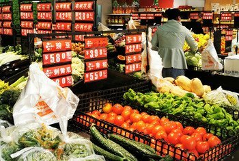 武汉一超市内，蔬菜柜台摆放着莲藕、青椒、黄瓜和番茄等。