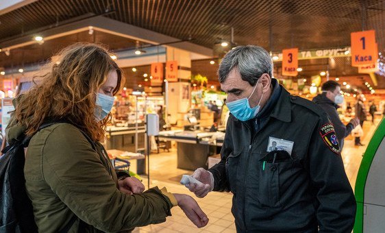 Clientes medem febre antes de entrar em loja em Kiev, na Ucrânia