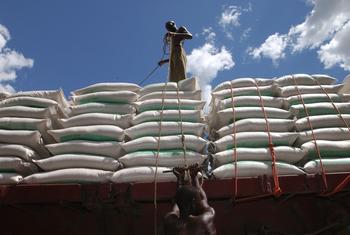 Trabajadores en el puerto de Dar Es Salaam, en Tanzania, cargan sacos de trigo en un camión.
