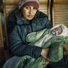 Mulher com bebê de dois meses em uma estação de trem em Uzhhorod depois de fugir do conflito na Ucrânia.