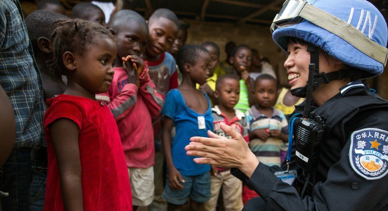 Une officiere de police chinoise déployée au sein de la Mission des Nations unies au Libéria (MINUL), parle à une jeune fille lors d'une patrouille.