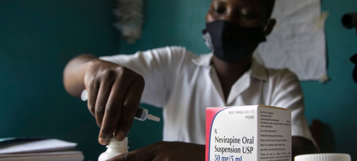 Uma parteira prepara remédios para um bebê HIV-positivo de duas semanas em Uganda.
