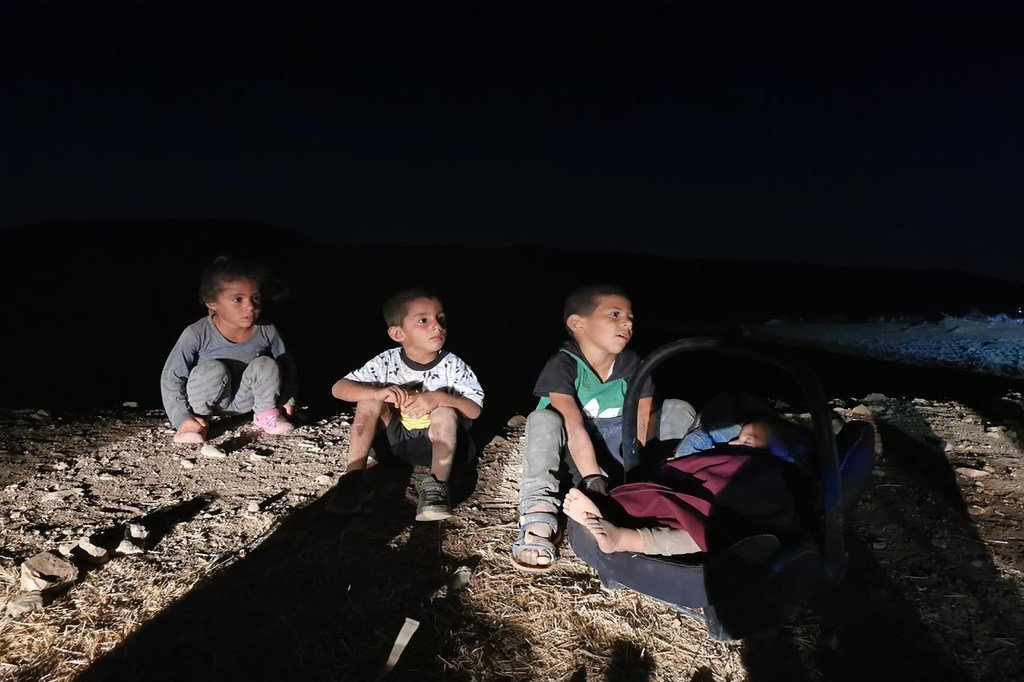 أطفال من حمصة البقيعة في العراء، بعد تسلُل الظلمة، في أعقاب هدم السلطات الإسرائيلية بيوتهم ومصادرة مقتنياتهم الشخصية بتاريخ 7 يوليو/تموز 2021