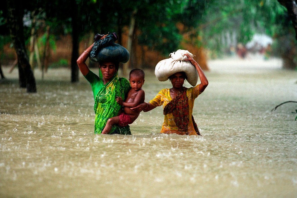 الناس يسيرون في فيضانات المياه في منطقة كوريغرام في بنغلاديش.