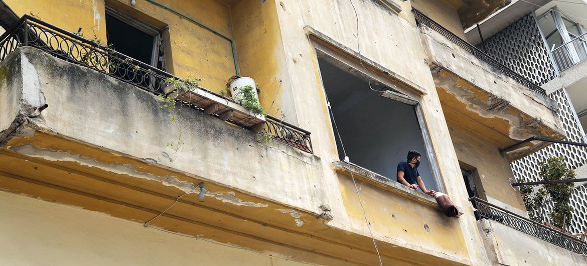 Young man stares out from his apartment after a blast at Beirut Port ripped through the city, Lebanon.