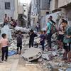 أطفال يقفون أمام مشاهد الدمار في قطاع غزة.