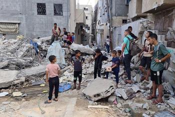 أطفال يقفون أمام مشاهد الدمار في قطاع غزة.