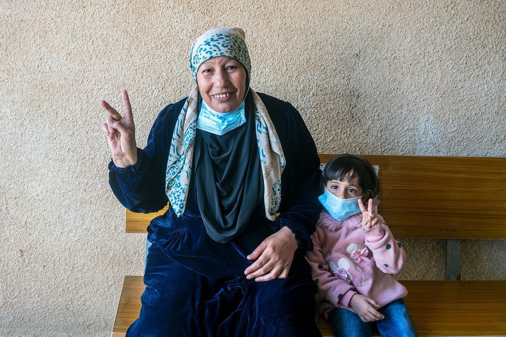 Une réfugiée syrienne avec sa petite-fille après avoir été vaccinée contre la Covid-19.