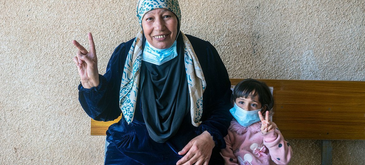 A Syrian exile  gives the ‘V for Vaccinated’ motion   with her granddaughter aft  receiving her COVID-19 vaccine successful  Za’atari Refugee Camp.