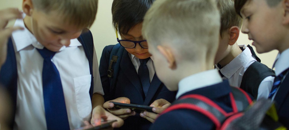 Children playing with their phones, as they wait for class to begin, in Almaty, Kazakhstan (September 2019).