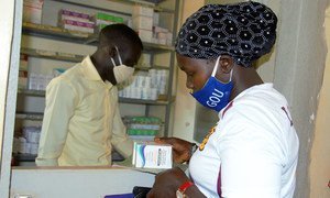 A woman living with HIV receives her medication at a health centre in Uganda during the COVID-19 pandemic.