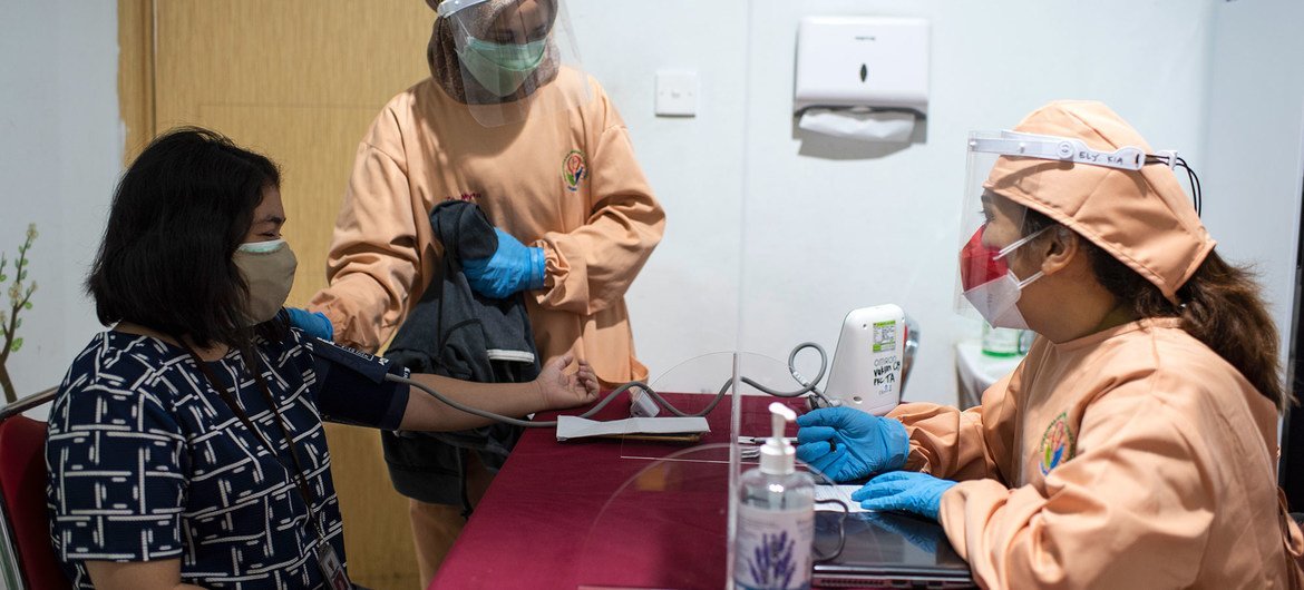 Une femme fait contrôler sa tension artérielle avant de recevoir une injection de rappel contre la Covid-19 en Indonésie.