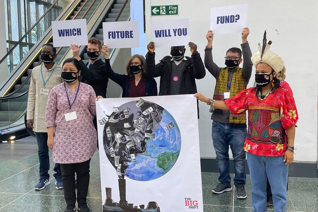 Un grupo armado con pancartas reivindicativas posa para los fotógrafos en el corredor principal de la zona azul en la Conferencia sobre el Clima, COP26, en Glasgow.