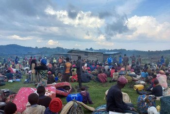 Um grupo de requerentes de asilo congoleses espera no ponto de fronteira, após cruzar para o Uganda devido aos conflitos