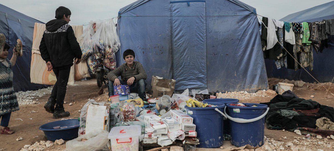 冲突导致近百万叙利亚西北部居民流离失所。照片中一个年轻的男孩在伊德利卜北部村庄的营地帐篷前等待购买东西的人。
