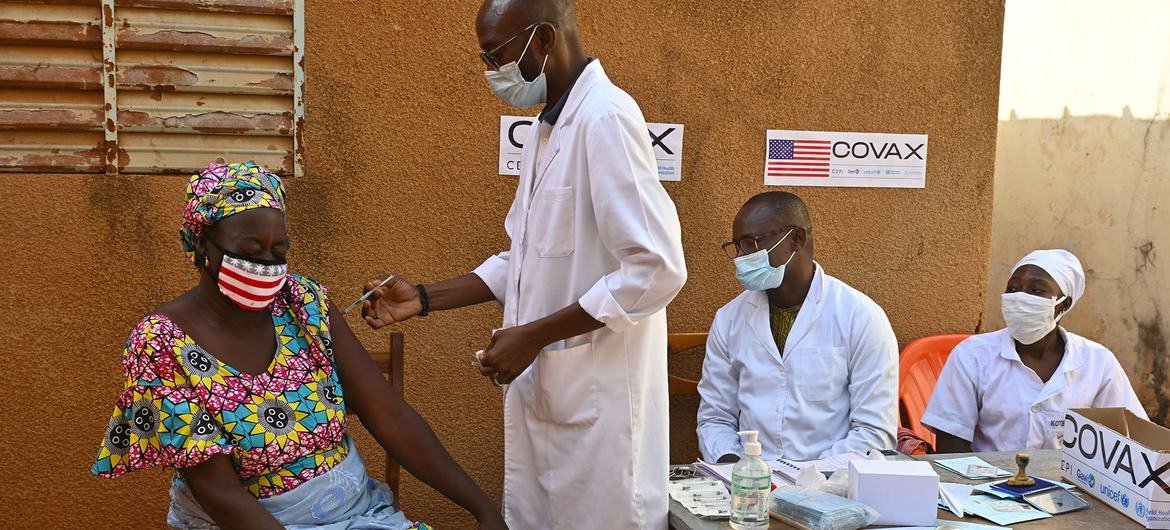 Une mère reçoit sa deuxième dose de la vaccination COVID-19 dans un centre de santé à Obassin, au Burkina Faso.