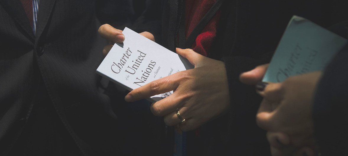 Senior UN officials hold copies of the UN Charter at UNHQ in New York.