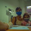 वेनेज़ुएला के काराकस के एक स्वास्थ्य केन्द्र में अपनी बेटी के साथ एक महिला.