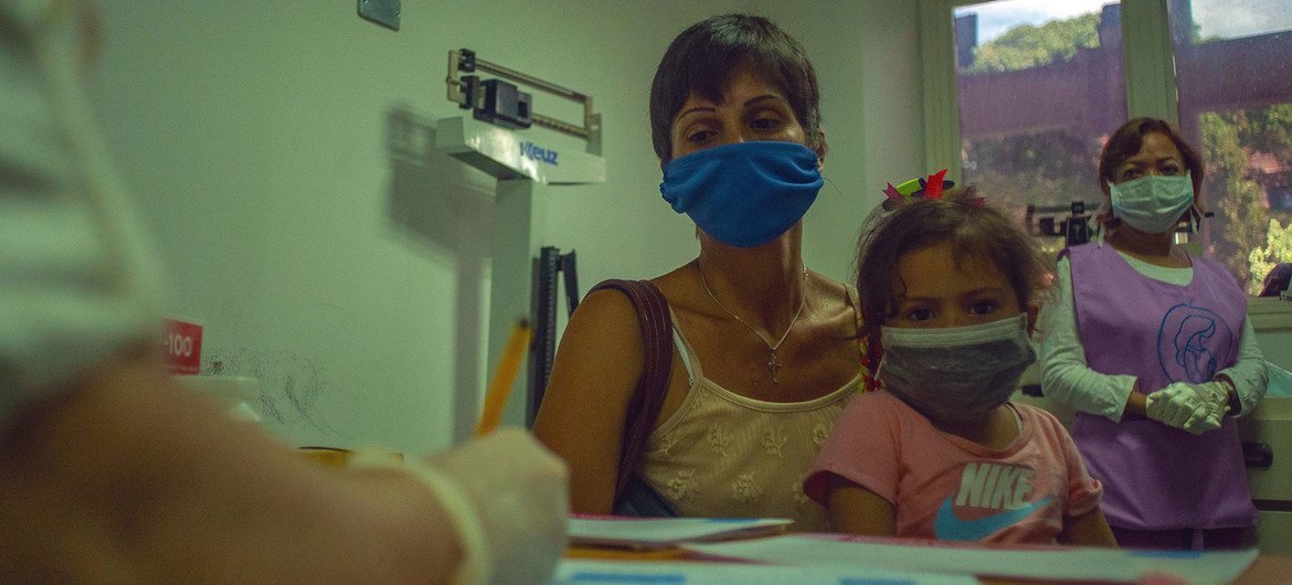 A mother brings her young girl to a medical appointment at a health centre in Caracas, Venezuela.
