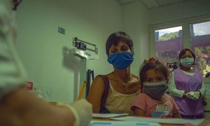 A mother brings her young girl to a medical appointment at a health centre in Caracas, Venezuela.