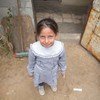 فتاة فلسطينية تقف أمام منزلها في مخيم خان يونس للاجئين الفلسطينيين في غزة.