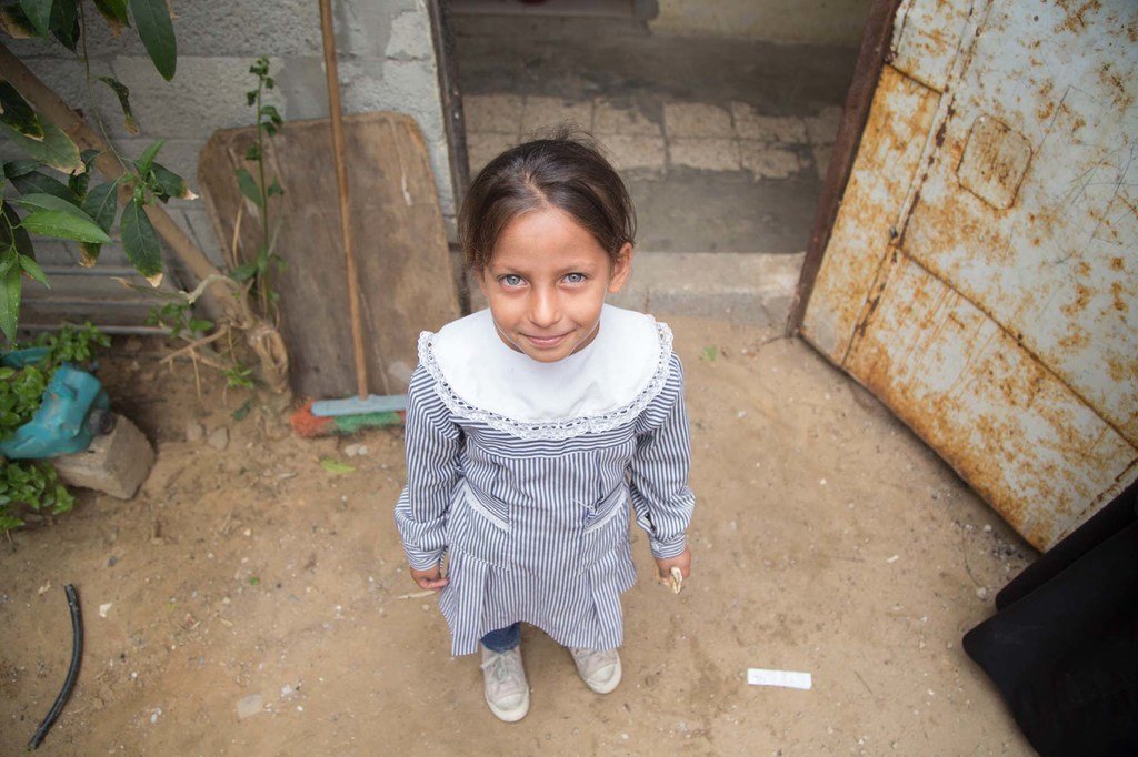 一个女孩站在加沙可汗尤尼斯巴勒斯坦难民营的家门前。