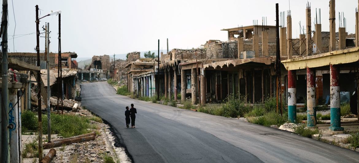 伊拉克儿童走过一个曾被达伊沙恐怖组织摧毁的市场。