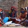 Члены группы фермеров анализируют данные о закупках в деревне Дханапур, штат Уттар-Прадеш, Индия.
