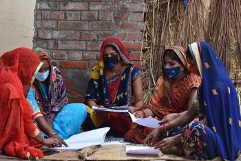 Des membres d'un groupe de producteurs agricoles calculent les chiffres des achats dans le village de Dhanapur, Uttar Pradesh, Inde.