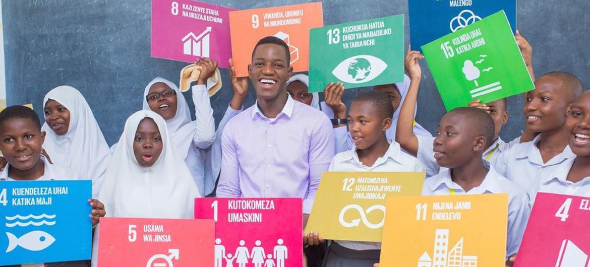 من الأرشيف: بول سينيجا (في الوسط) سفير تنزانيا لأهداف التنمية المستدامة للشباب وحملة He4She في صورة جماعية مع فتيات. 