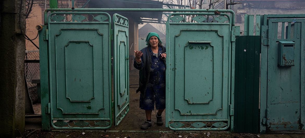 Uma mulher olha para sua casa danificada após um bombardeio em Mariupol, no sudeste da Ucrânia.