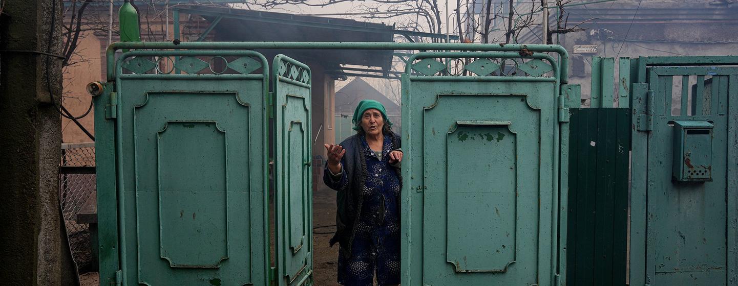 Une femme regarde sa maison endommagée après un bombardement à Marioupol, dans le sud-est de l'Ukraine.