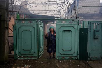 Mulher observa sua casa destruída por bombardeios em Mariupol, Ucrânia. 