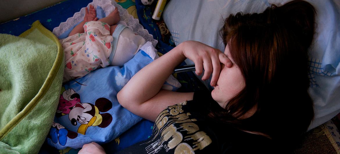 فتاة تبلغ من العمر 18 عامًا تنام بجانب طفلها المولود حديثًا في ملجأ للنساء اللائي يعانين من مشكلة الإدمان في بيشكيك، قرغيزستان.