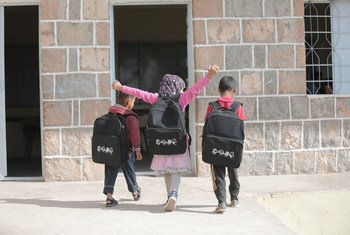 أطفال صغار يسيرون في تعز المتضررة بسبب الصراع في اليمن وقد حصلوا على حقائب مدرسية جديدة في كانون الثاني-يناير 2020