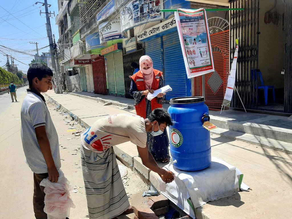 孟加拉国红新月会的工作人员和志愿者倡导洗手，喷洒消毒剂并提供紧急食品，以抗击2019冠状病毒。