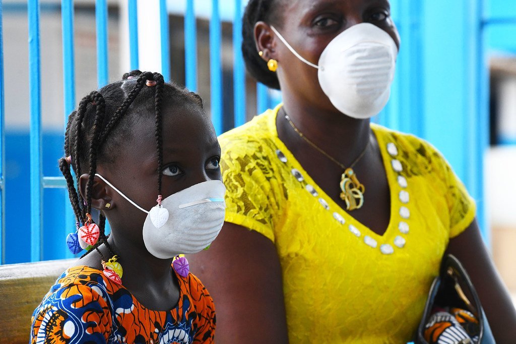 Une mère et sa fille portent un masque pour se protéger contre le coronavirus dans un centre de santé à Abidjan, en Côte d'Ivoire.