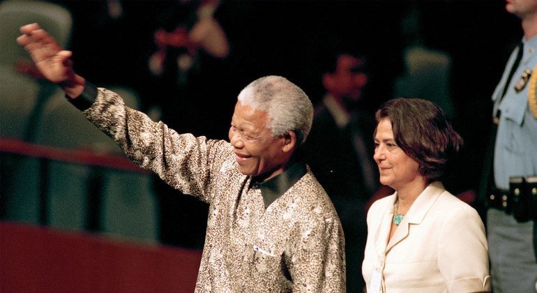 Nelson Mandela (left), President of South Africa, enters the General Assembly Hall to address its fifty-third session. At his side is United Nations Chief of Protocol, Nadia Younes, 21 September 1998