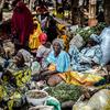Des femmes vêtues de tenues traditionnelles colorées sont assises à un étal de marché à Tanout, au Niger, vendant des produits à base de gombo.